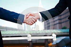 Two Asian business men shake hands
