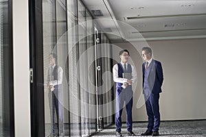 two asian business men standing and talking in office