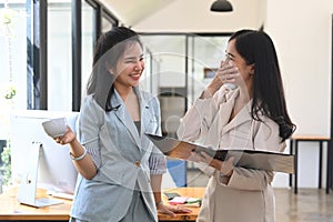 Two asian business women  having coffee break at office.