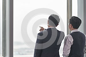 Two asian businessmen talking in office