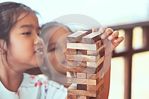 Two asian child girl playing wood blocks stack game