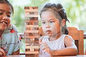 Two asian child girl playing wood blocks stack game