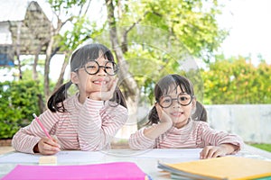 Two Asian Children Doing Homework Together at home