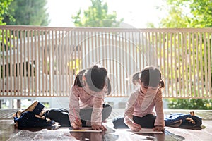 Two Asian Children Doing Homework Together at home