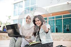 Two asian college student using laptop