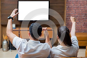 Two asian couple see the television on sofa