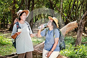 Two Asian elderly women hiking travel nature Drink water to quench your thirst.
