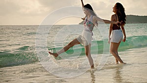 Two Asian girl friends are having fun on the beach while on vacation. concept of freedom, travel, adventure.