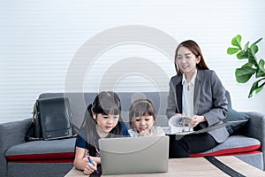 Two Asian girls looking at notebook computer with interest