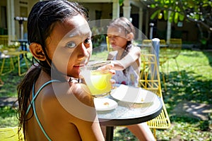 Two Asian Girls in Swimsuit Having Some Meals and Drinking Juice. Having Fun Together After Swimming Activities