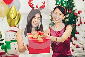 Two Asian girls teen in happiness Christmas New Year Eve moment cellebration give the Gift box
