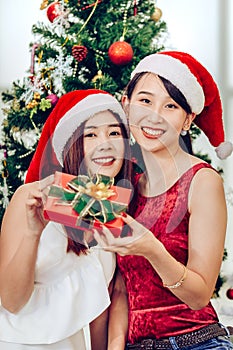 Two Asian girls teen in happiness Christmas New Year Eve moment cellebration present Gift box vertical shot