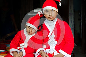 Two Asian Indian Ethnicity kids wearing Santa Hat waving having