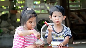 Two asian kids boy and girl eat ice cream