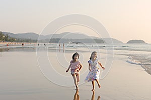 Two Asian kids running on beach