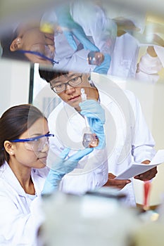 Two Asian Laboratory scientist working at lab with test tubes