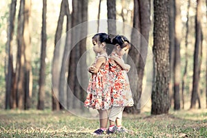 Two asian little girls hug their chest