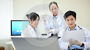Two Asian scientist working, meeting with an Asian senior female scientist in the laboratory