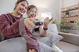 Two Asian sisters watch TV together. relax at home Enjoy watching television