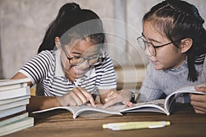 Two asian student reading a school book with happiness emotion