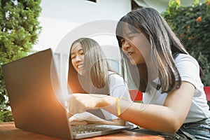 Two asian teenager happiness and looking to computer labtop photo