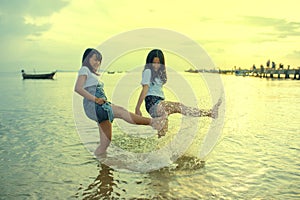 Two asian teenager relaxing and playing ons summer vacation sea beach photo
