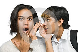 Two Asian teenagers gossiping