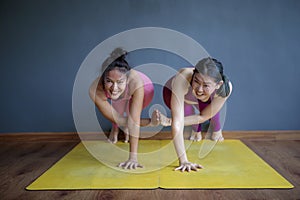 two asian woman doing yoga pose with happiness face