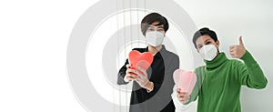 Two Asian woman friends wearing mask with heart balloon support and encourage people form Covid-19 pandemic