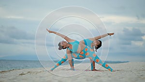 Two asian woman playing yoga pose on sea beach
