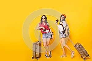 Two Asian woman traveller with suitcase in studio.