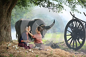 Two Asian woman wearing traditional thai Esan custom style culture sitting in field