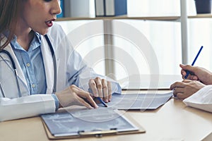 Two asian women doctors discuss meeting doctor`s office medical clinic looking x-ray film consulting patient disease. Asian