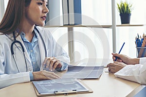 Two asian women doctors discuss meeting doctor`s office medical clinic looking x-ray film consulting patient disease. Asian