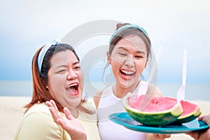 Two Asian women Happy smiling eating watermelon.