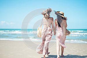 Two Asian women jogging on the beach in the morning. Rest time and holidays