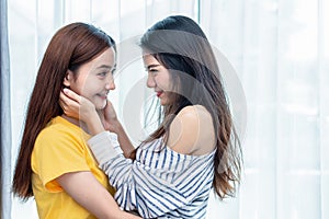 Two Asian women looking at each others in home. People and lifestyles concept.  LGBT pride and lesbian theme photo
