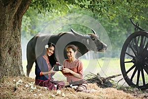 Two Asian woman wearing traditional thai Esan custom style culture sitting in field