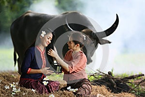 Two Asian woman wearing traditional thai Esan custom style culture sitting in field