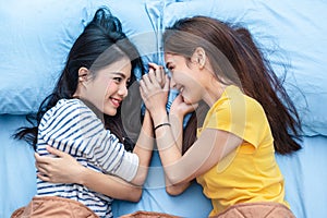 Two Asian womens looking at each others when lying on bed. Lifestyles and lovers concept. Happiness life and relax concept.