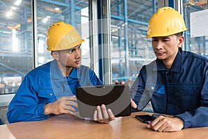 Two Asian workers analyzing information indoors