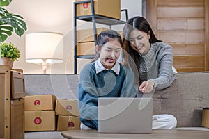 Two Asian Young business woman on sofa at home. startup sme small business entrepreneur SME distribution warehouse with