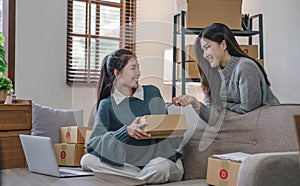 Two Asian Young business woman on sofa at home. startup sme small business entrepreneur SME distribution warehouse with
