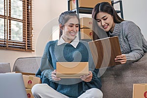 Two Asian Young business woman on sofa at home. startup sme small business entrepreneur SME distribution warehouse with