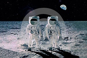 Two astronauts on the moon, with planet earth in the background. Elements of this image were furnished by NASA