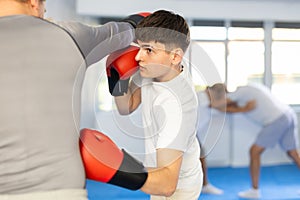 Two athlete men in sportswear practicing boxing sparring in hall