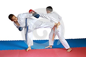 Two athletes in karategi are beating karate blows