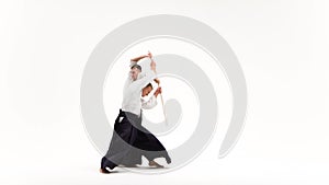 Two athletes performing aikido using bokken. Isolated, white. Close up.