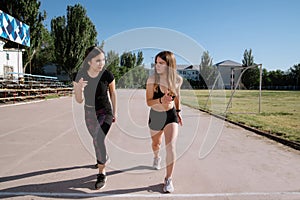 Two athletes at the starting position in the stadium. Athletic girls run in the stadium