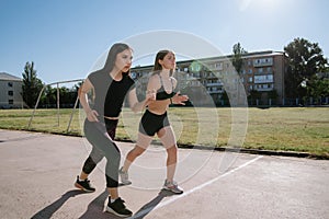 Two athletes at the starting position in the stadium. Athletic girls run in the stadium